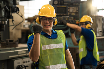 An engineer working in the the industrial. Yellow hard safety helmet for safety accident and safety goggles mask. Excited engineer celebrating.