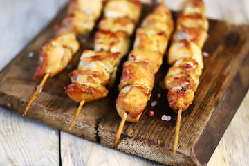 Appetizing chicken skewers on wooden sticks.