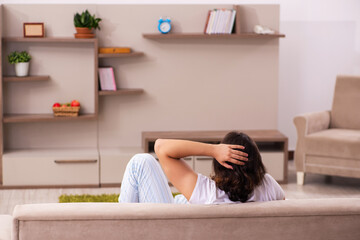 Young lazy man in oversleeping concept at home
