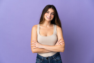 Young caucasian woman isolated on purple background keeping the arms crossed in frontal position