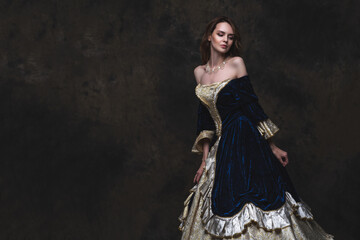 Beautiful woman in renaissance dress on abstract dark background