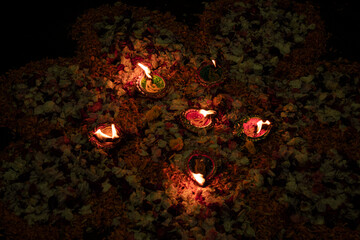 Floor decorated with diyas and flowers on the occasion of diwali