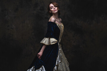 Obraz na płótnie Canvas Beautiful woman in renaissance dress on abstract dark background