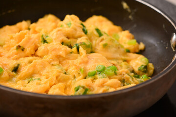 Fototapeta na wymiar closeup of fried eggs with onions in a pan