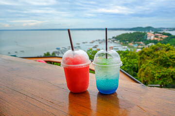 Red nectar and blue nectar on the table with sea view.
