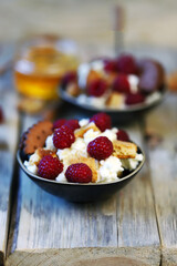 Delicious dessert with mascaraone, cookies and raspberries in a small dessert plate. Healthy sweets. Keto dessert.