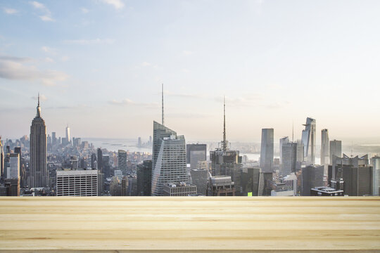 Blank table top made of wooden planks with beautiful New York cityscape at daytime on background, mockup