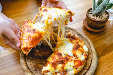 A slice of fresh hot Very cheesy vegetarian pizza mozzarella cheese. Italian Pizza Margherita in hand
