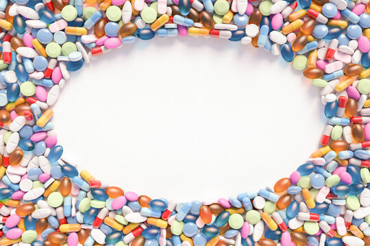 Top down view of assorted pills and tablets in an oval frame on white surface with space for text and images. 3d illustration of multi colored medicines.