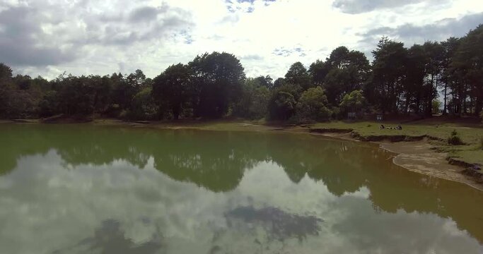 Pristine Green Guarne Lagoon in the Middle of the Woods near Medellin, Colombia on a Cloudy Day shot from in Smooth Travelling form Above