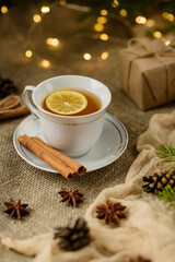 A cup of lemon tea, shot with selective focus, against a backdrop of Christmas decorations.