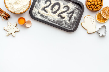 Flat lay of Christmas cooking with icing gingerbread cookies, top view