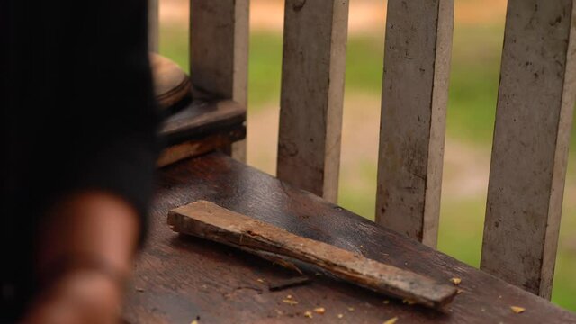 Close up of woman choppin wood.  Woman in rustic kitchen chopping wood.
