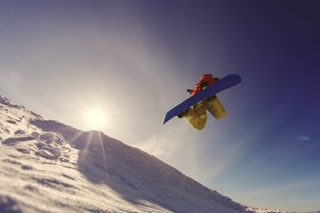 Fototapeta na wymiar Snowboarder jumping against the sunset sky
