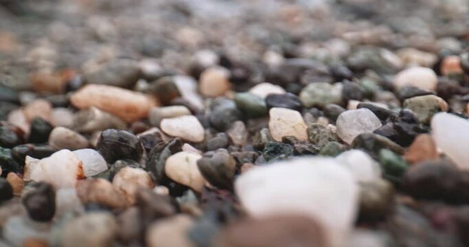 Dolly shot of pebbles at the beach.
