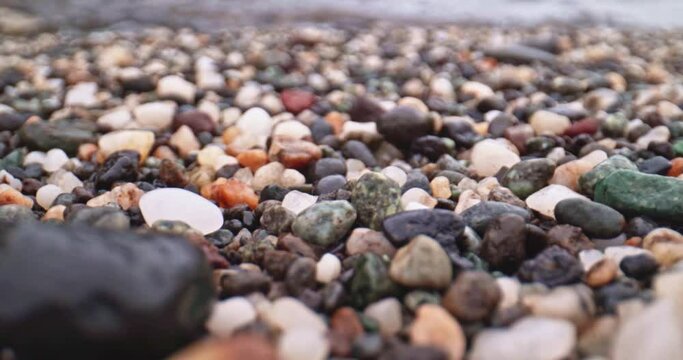 Dolly shot of pebbles at the beach.