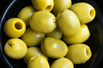 green olives in a black bowl close up
