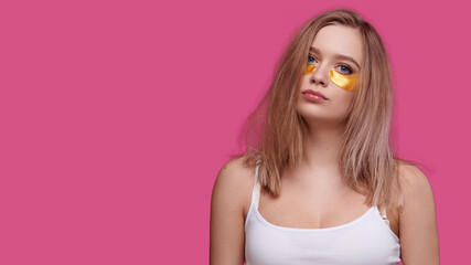 Woman with patches under eyes on pink isolate background. Tired girl with hangover