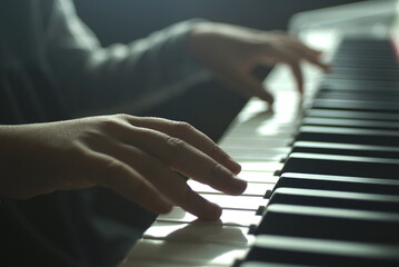 Fototapeta na wymiar girl's hands on the piano keyboard close up