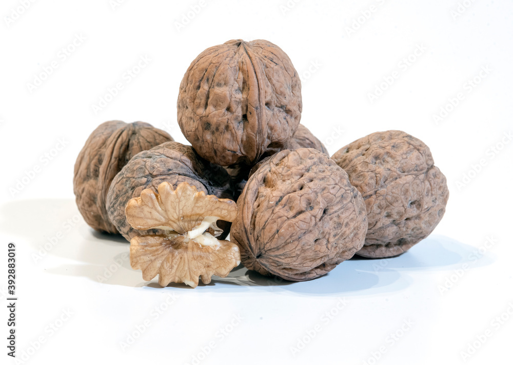 Wall mural walnuts in close-up on white - composition of a group of walnuts - seasonal fruit