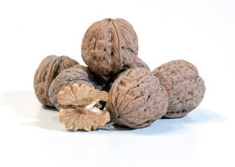 walnuts in close-up on white - composition of a group of walnuts - seasonal fruit