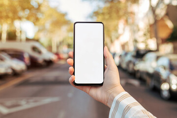 Mockup of a phone held by a woman's hand on the street