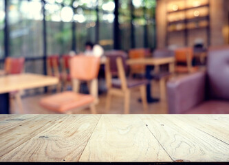 wood table on blur of cafe, coffee shop, bar, resturant, background - can used for display or montage your products
