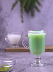 Cup of hot green matcha latte with almond milk