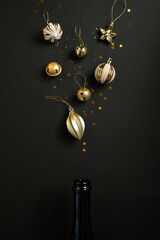 Champagne bottle with different christmas decoration on black background. New year concept.