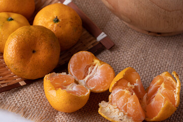 Tangerines in wooden bowls on gray background