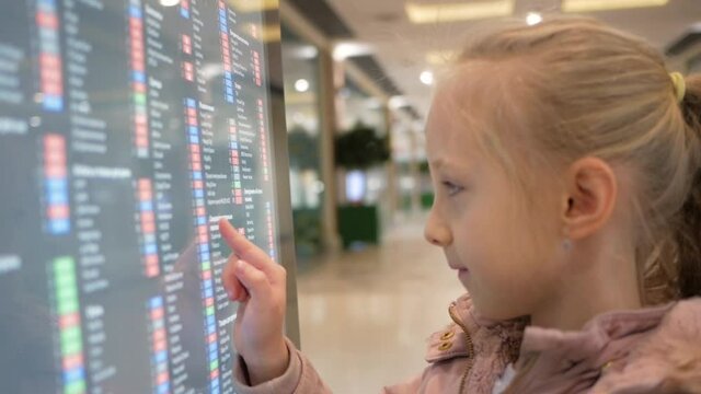 a little girl examines a map of the mall through a tablet