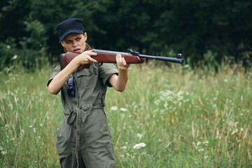 Woman Holding a weapon aiming hunting fresh air green overalls