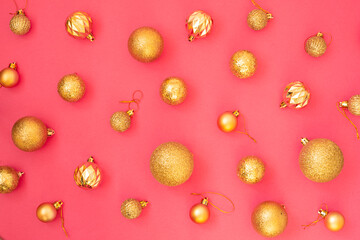 Gold glitter. Christmas balls of different sizes on a pink background pattern. Flat lay, top view