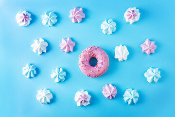 Pink, blue and merengue cookies with pink donut on a blue background