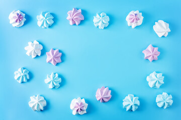 Pink, blue and merengue cookies on a blue background.