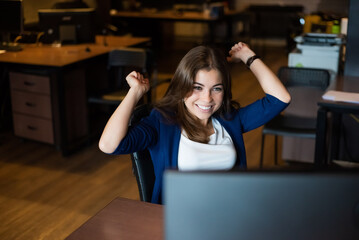 Joyful woman at her desk in the office