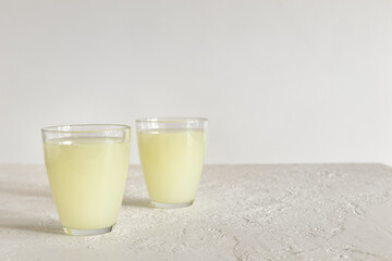 Two glasses of natural whey on a bright background with copy space