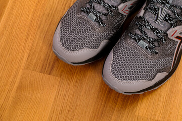 New gray running shoes on parquet.