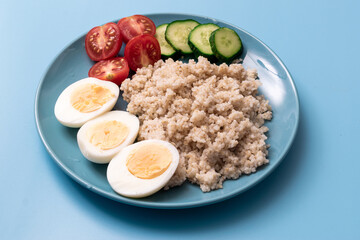 Healthy food, diet. Barley porridge and chicken eggs on a blue background.