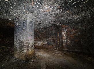 The basement of an old house with a domed vault and a supporting column. The picture was taken in...
