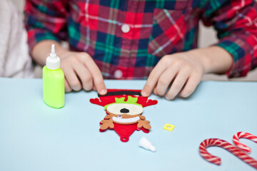Fototapeta na wymiar Kids making decor for Christmas tree or gifts. Christmas handmade diy project.