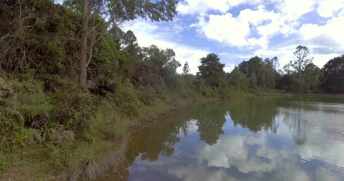 Pristine Green Guarne Lagoon in the Middle of the Woods near Medellin, Colombia on a Cloudy Day shot from in Smooth Travelling form Above