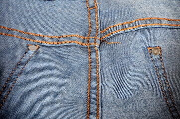 Texture of blue jeans from the inside with yellow thread seams