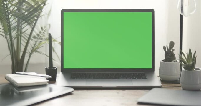Green screen freelance Graphic Designer's laptop computer home work desk station next to a lamp and plants. Drawing tablet, digital pencil shown in stunning 4K.