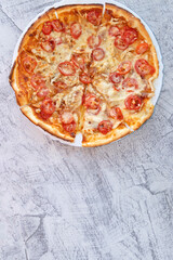 Homemade pizza on a white plate on a white background with a place for text. Copy space.