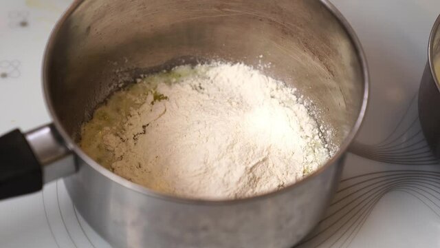 cooking bechamel sauce. The flour and hot milk are added to the melted butter. for lasagna. Italian cuisine at home.