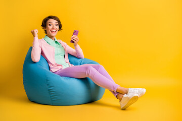 Photo of lucky brown hair bob woman wear pink outfit sitting beanbag chatting gadget isolated...