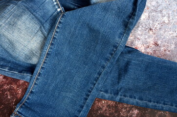 blue jeans pants fragments on an old rust background. Closeup of the detail of blue jeans