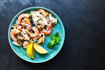 seafood salad assortment appetizer shrimp, mussels, squid and other healthy meal snack on the table top view copy space for text food background rustic pescetarian diet