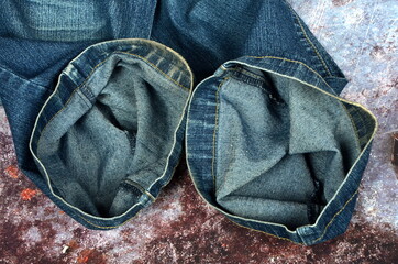 blue jeans pants fragments on an old rust background. Closeup of the detail of blue jeans